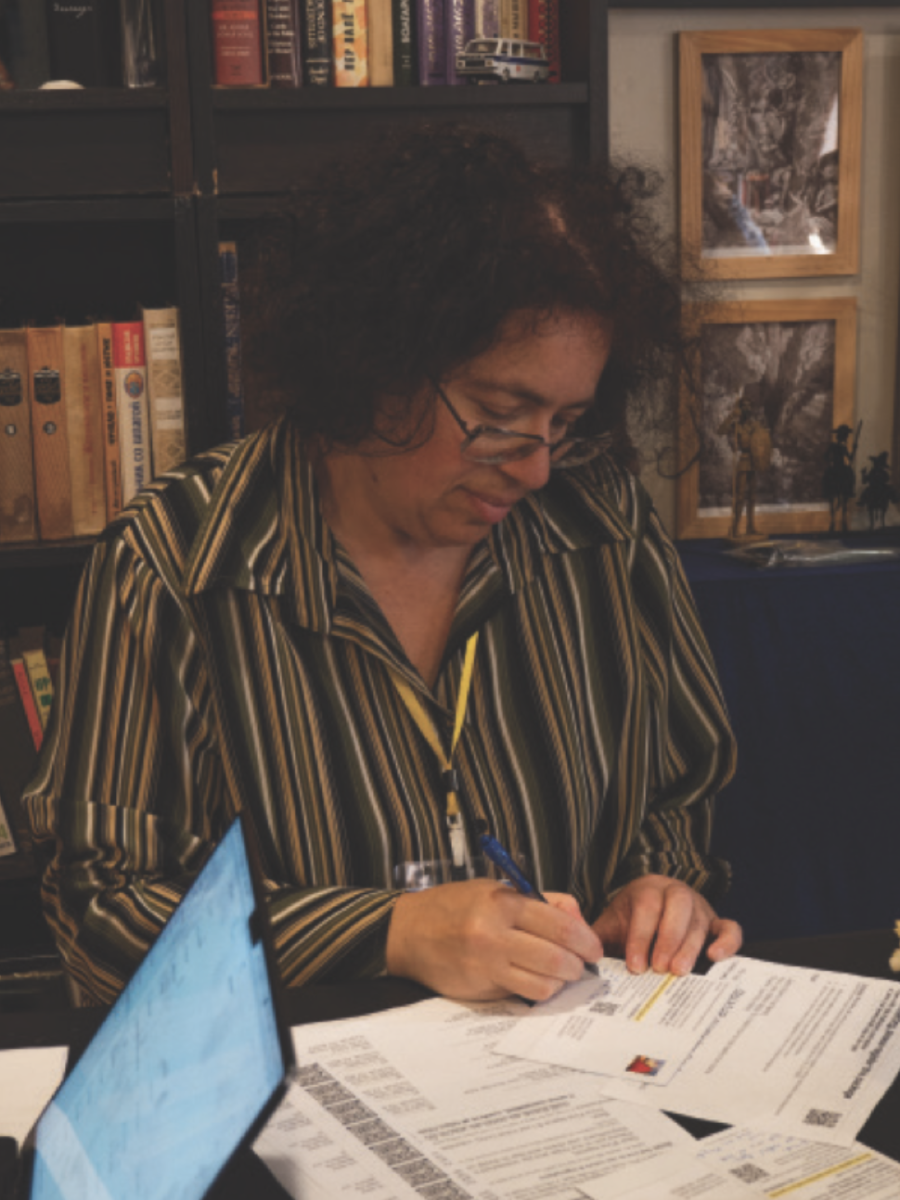 Event organizer Mariya Genzel writes postcards to residents in the swing state of Wisconsin telling them to vote in the upcoming 2024 presidential election. Photo by Alexander Lawson.